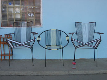 3 chairs infront of blue building